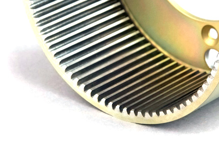 a close-up of a curved gear or cogwheel, focusing on the precision-cut teeth that line its semi-circular edge. The gear appears to be made of a metal with a finely machined surface, highlighting the quality of the manufacturing process. The individual teeth are uniformly spaced and shaped, suggesting the part's design for efficient and accurate meshing with other gears within a mechanical system. This component could be part of an intricate machine where the transfer of motion or torque is critical, such as in aerospace, automotive, or industrial machinery. The overall image conveys a sense of the precision engineering involved in creating such a component.